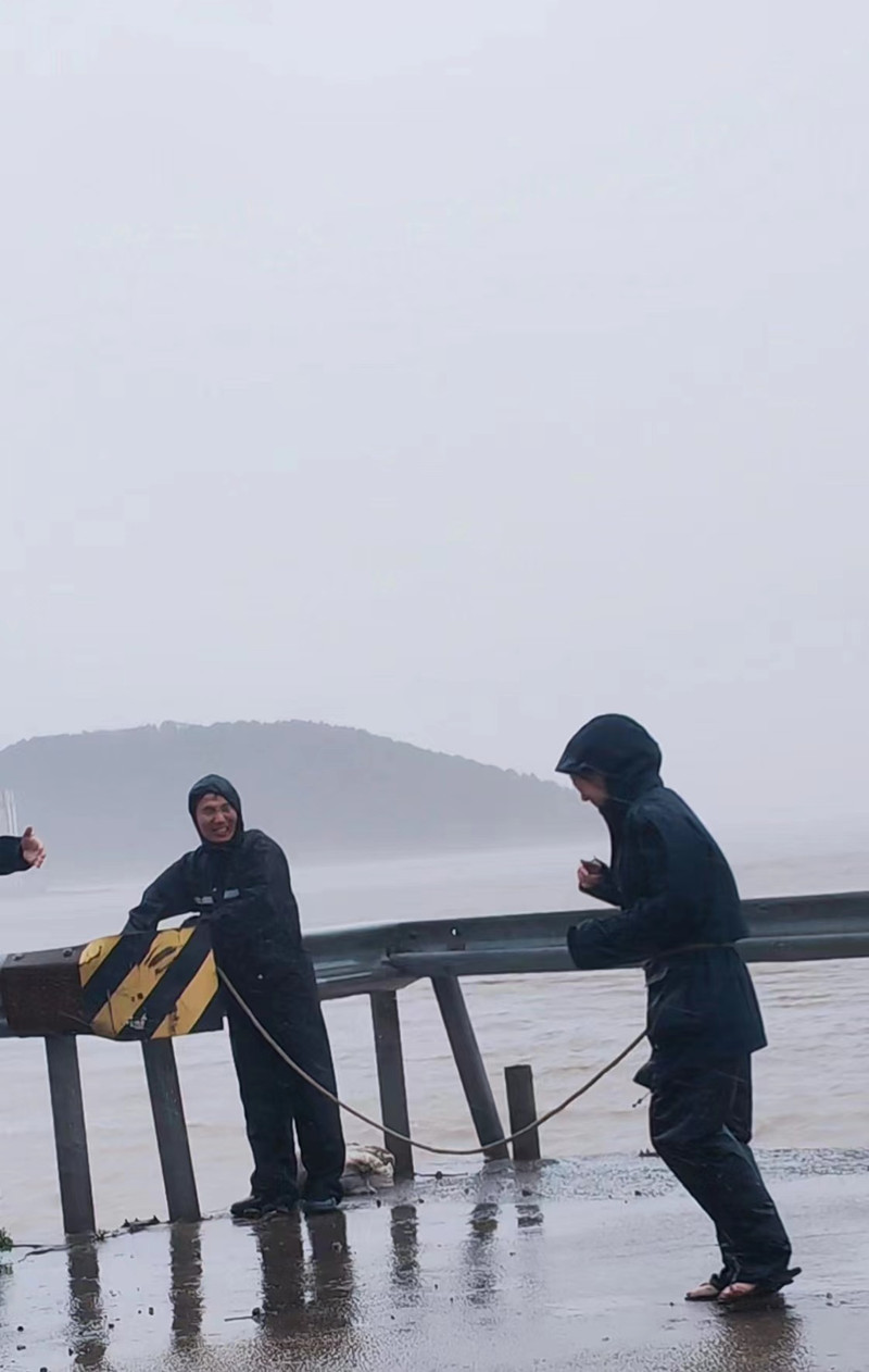 多媒體新聞中心記者在梅山島梅東村的盤峙碼頭，瞬時(shí)的風(fēng)力達(dá)到了14級(jí)，人都被風(fēng)吹著跑，村干部見狀趕緊在記者和攝像腰上綁上繩子。.jpg